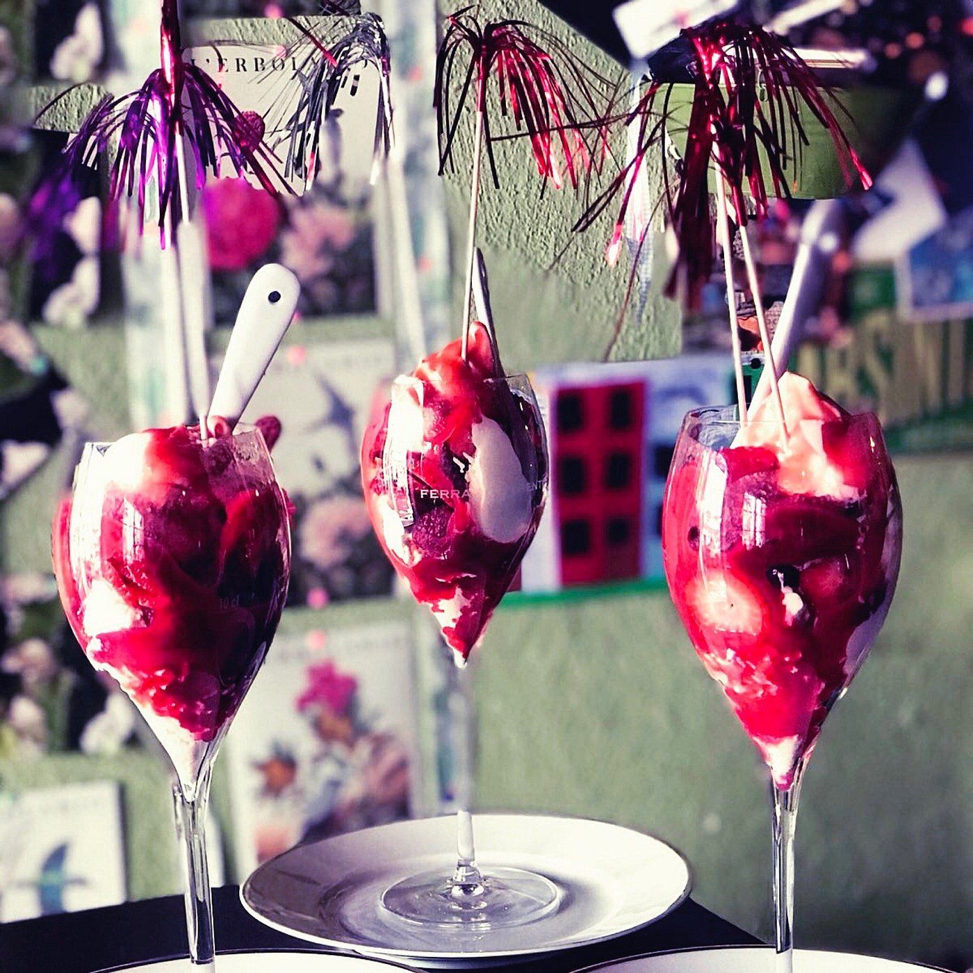 Strassencafé mit Tischen, Sonnenschirmen und Gästen; Lage am Wasser, sonniger Tag.