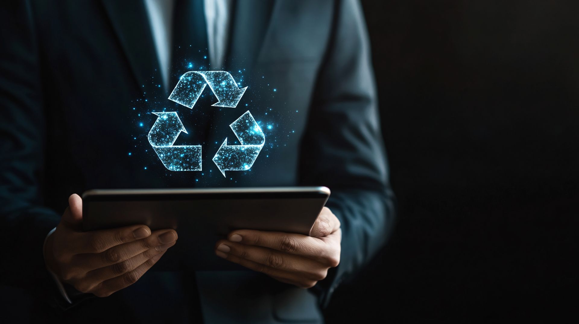 Persona con traje sosteniendo una tableta con un símbolo de reciclaje brillante encima.