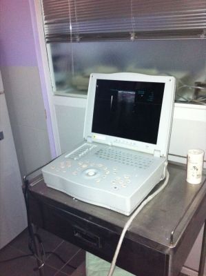 Una computadora portátil blanca está sobre una mesa de acero inoxidable.