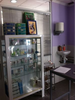 Una habitación morada y blanca con una vitrina de cristal y una mesa.