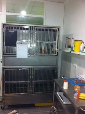 Una habitación con una jaula y un portapapeles en la pared.