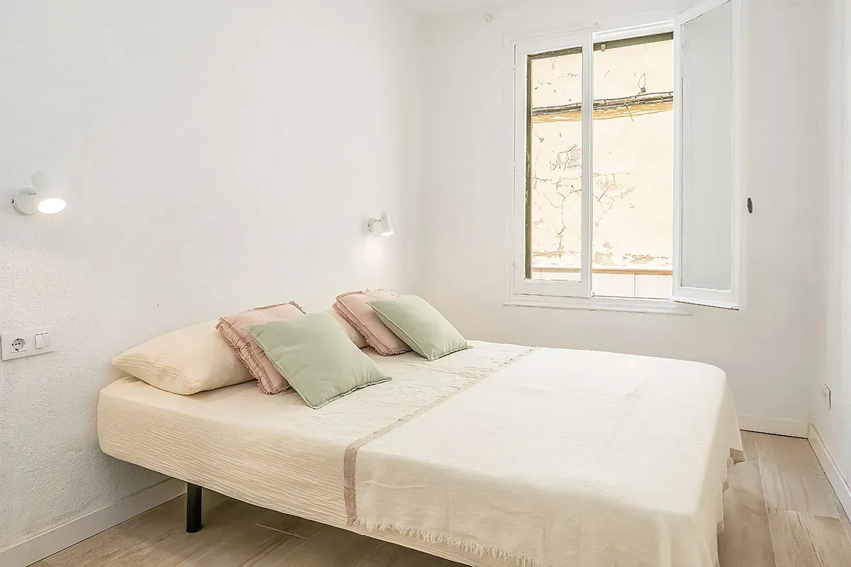 Un dormitorio con una cama grande y una ventana.