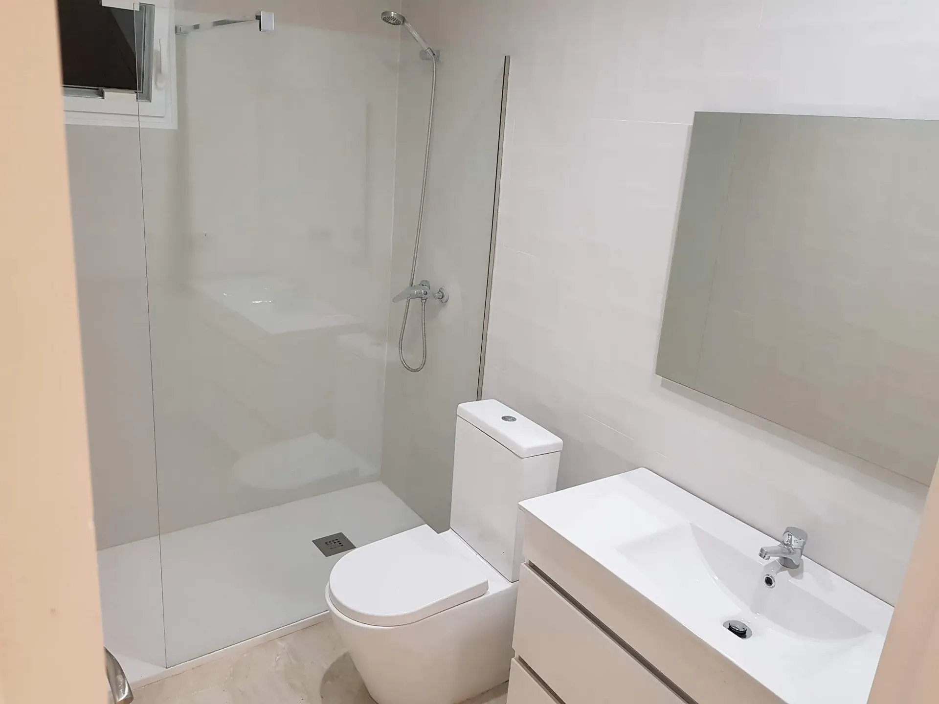 Un baño con inodoro, lavabo y ducha.