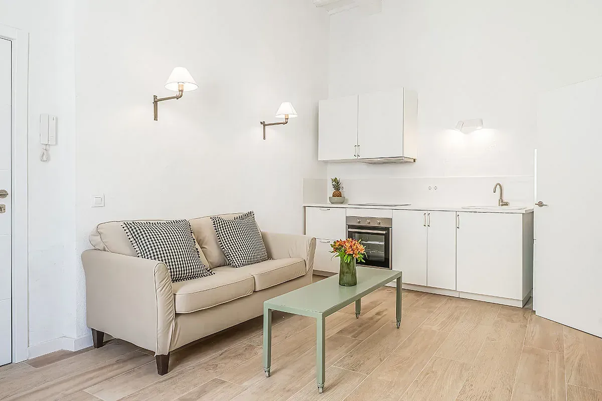 Una sala de estar con sofá, mesa de café y cocina.