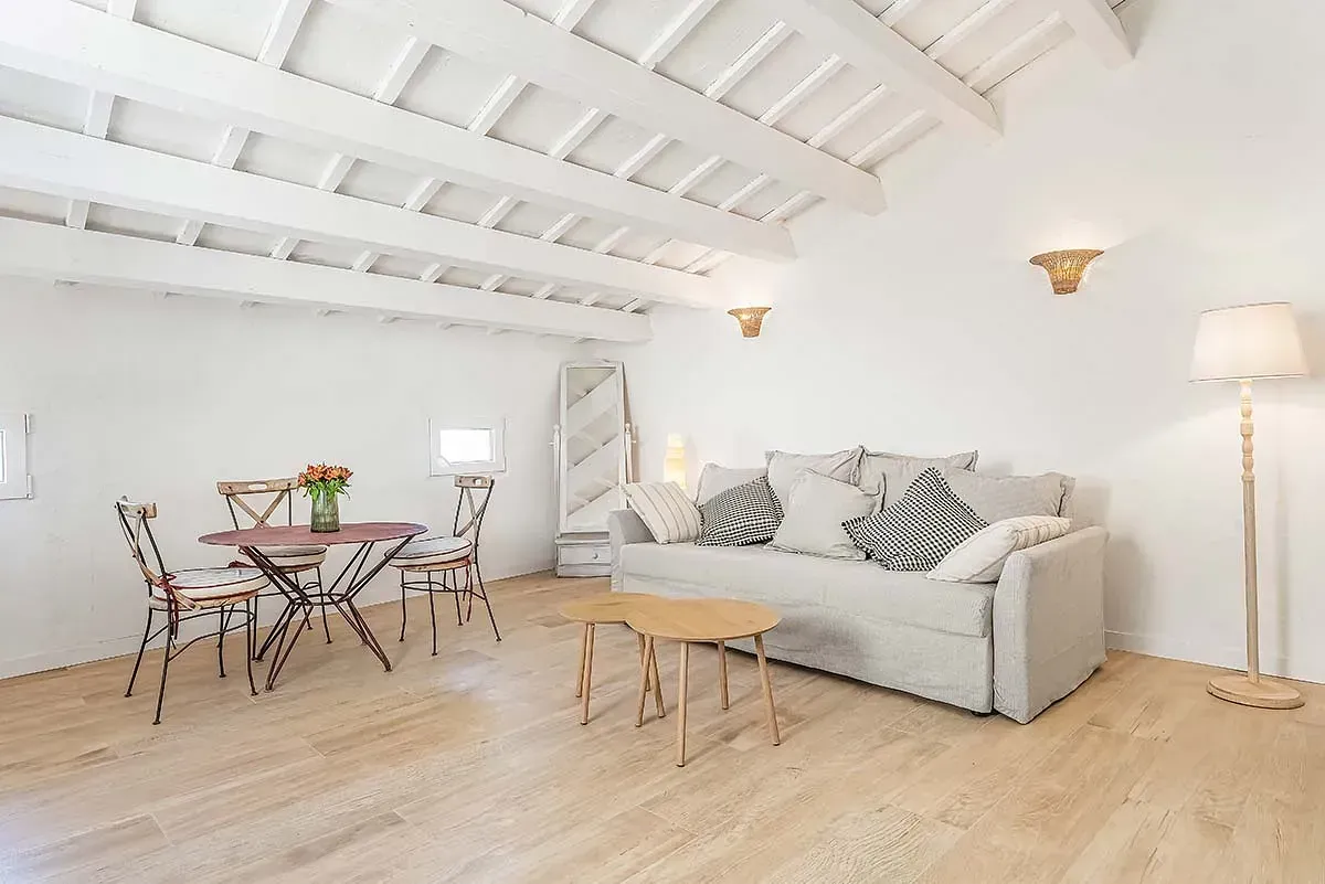 Una sala de estar con sofá, mesa y sillas.