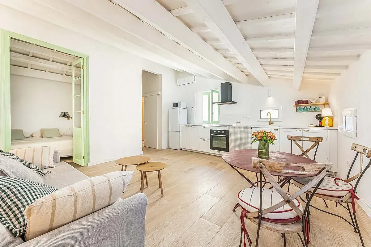 Una sala de estar con sofá, mesa y sillas.