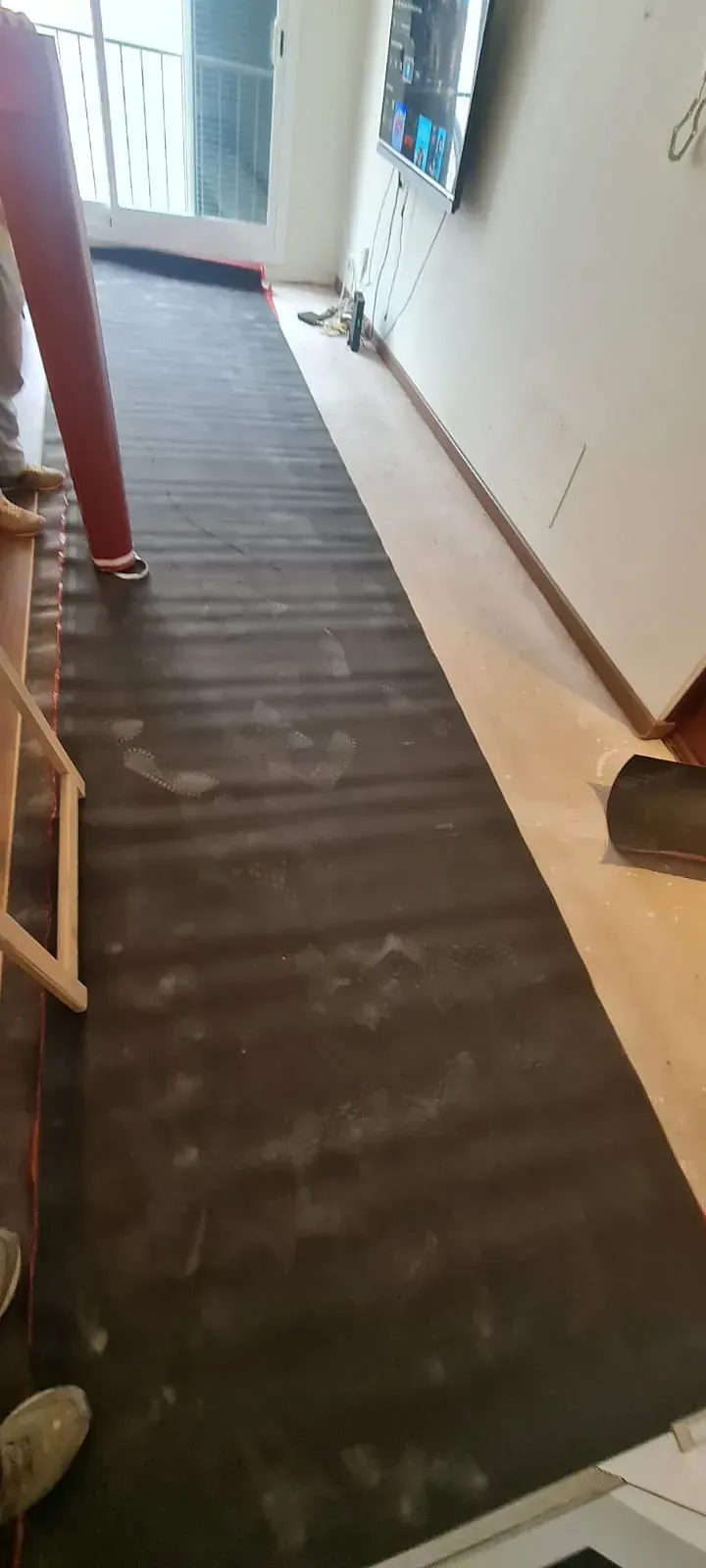 Una persona está de pie sobre un piso de madera en una sala de estar.