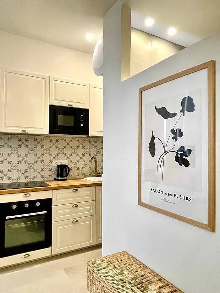 Una cocina con un cuadro de flores en la pared.