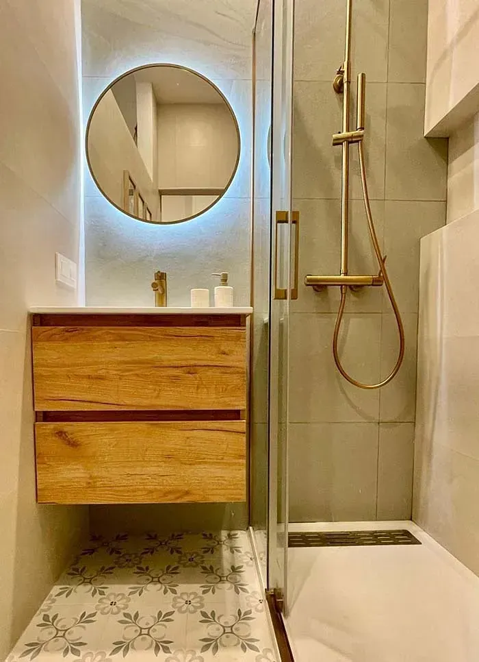 Un baño con lavabo, ducha y espejo.