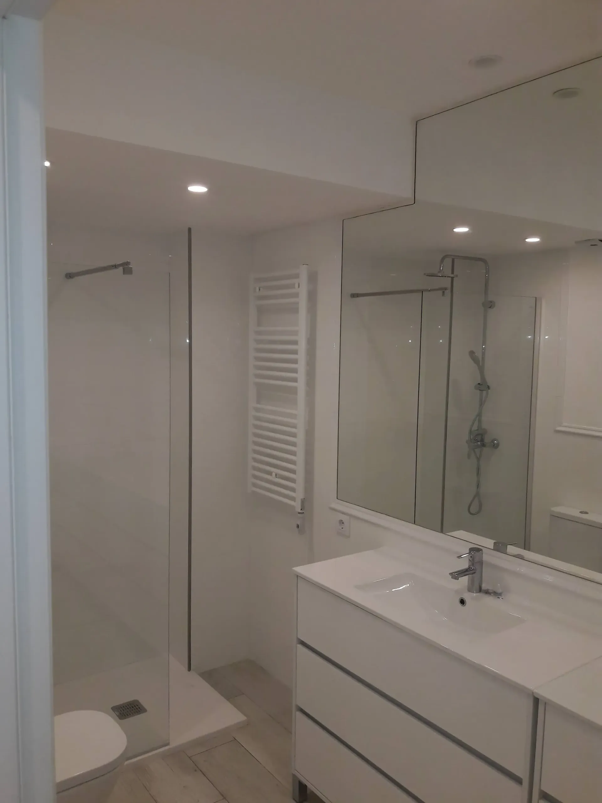 Un baño con lavabo, inodoro, ducha y espejo.