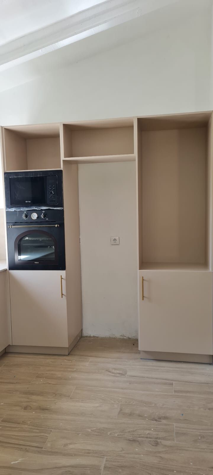 Una cocina con horno microondas y nevera.