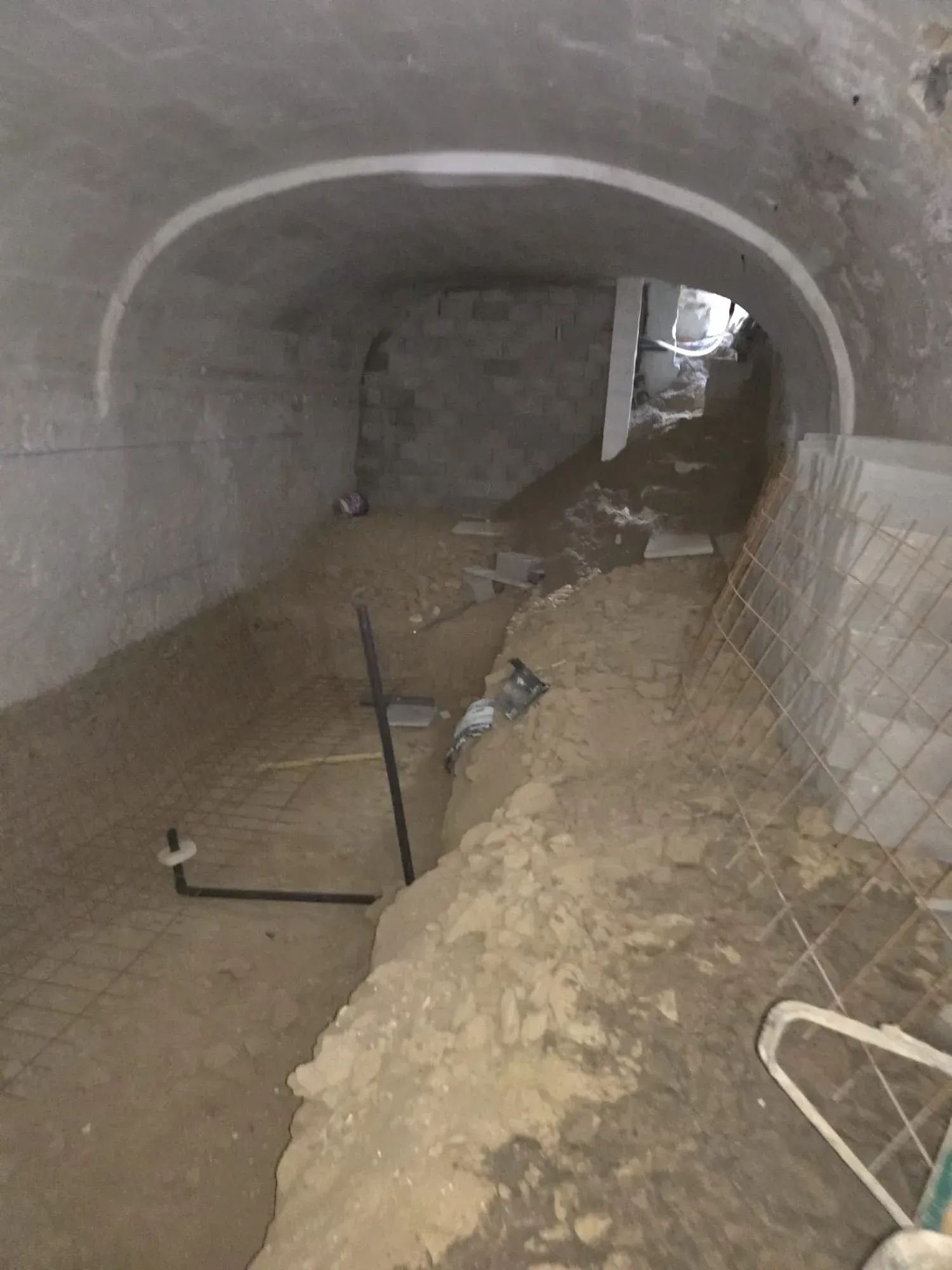 Un túnel lleno de tierra y una escalera en el medio.