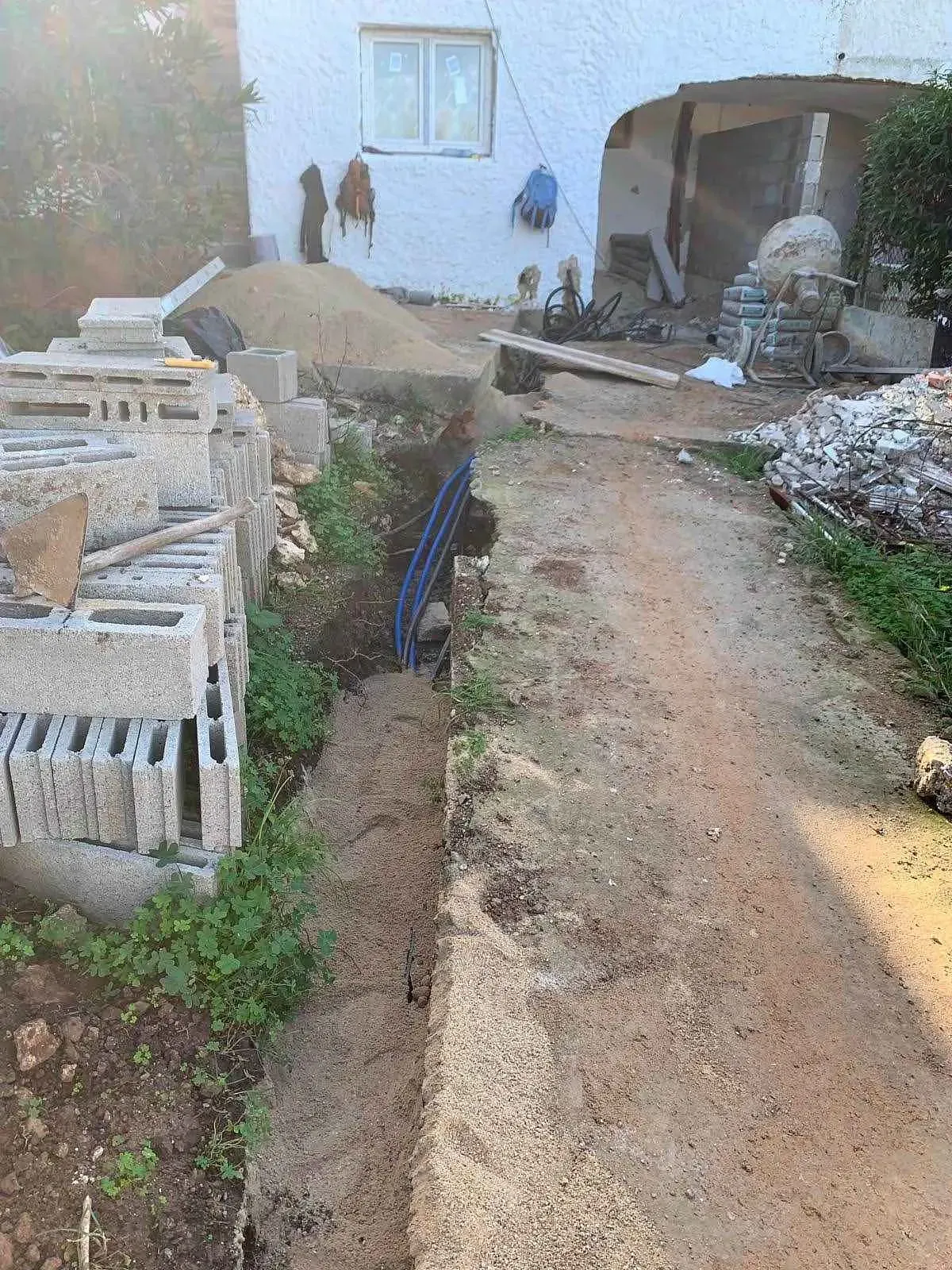 Un camino de tierra que conduce a una casa en construcción.