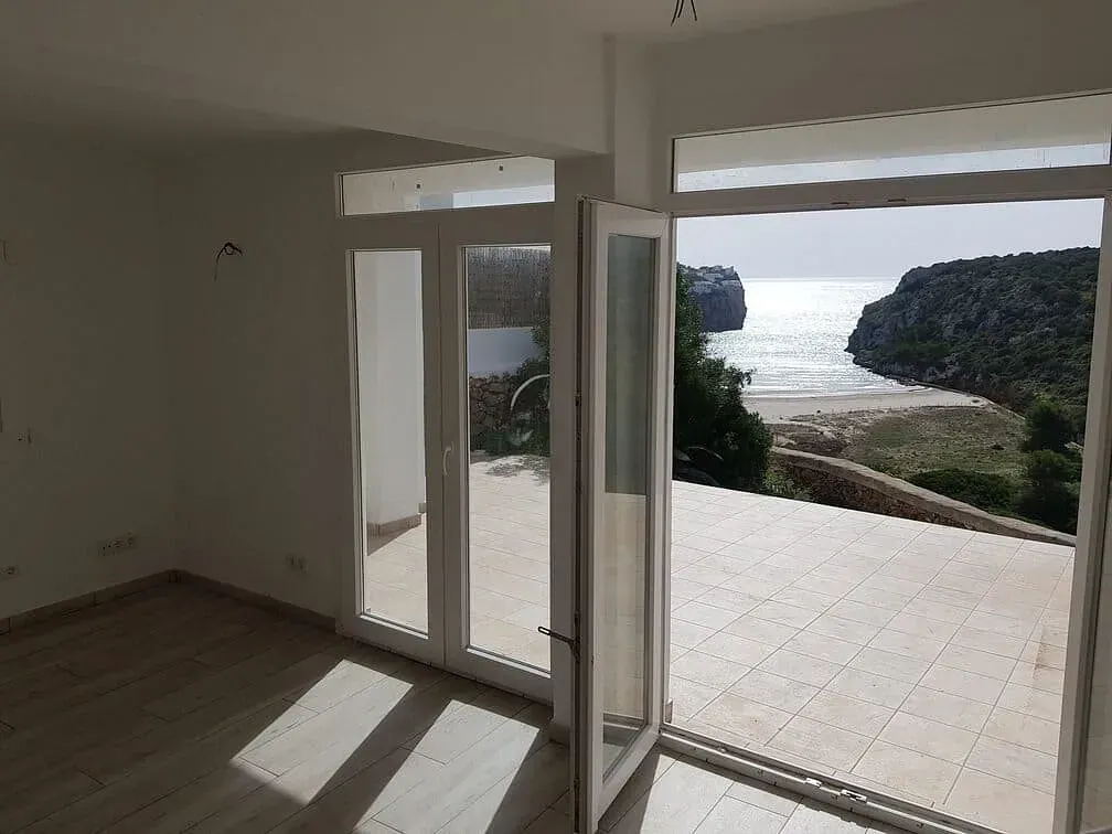 Una habitación vacía con vista al mar desde el balcón.
