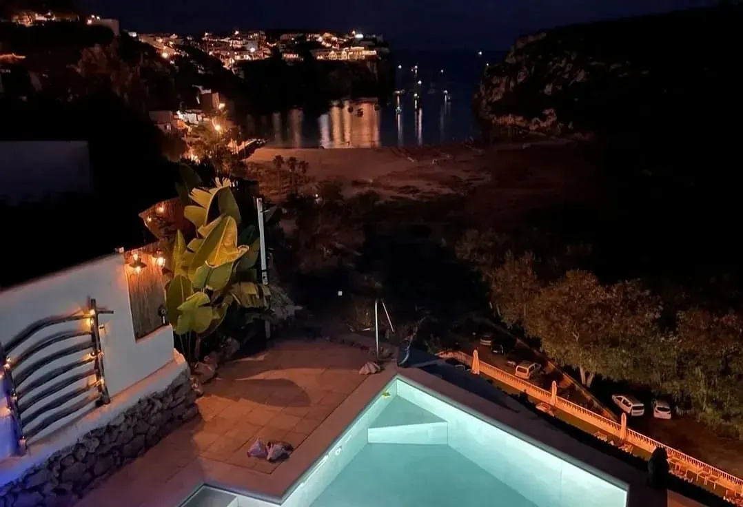 Una piscina con vista al mar por la noche.
