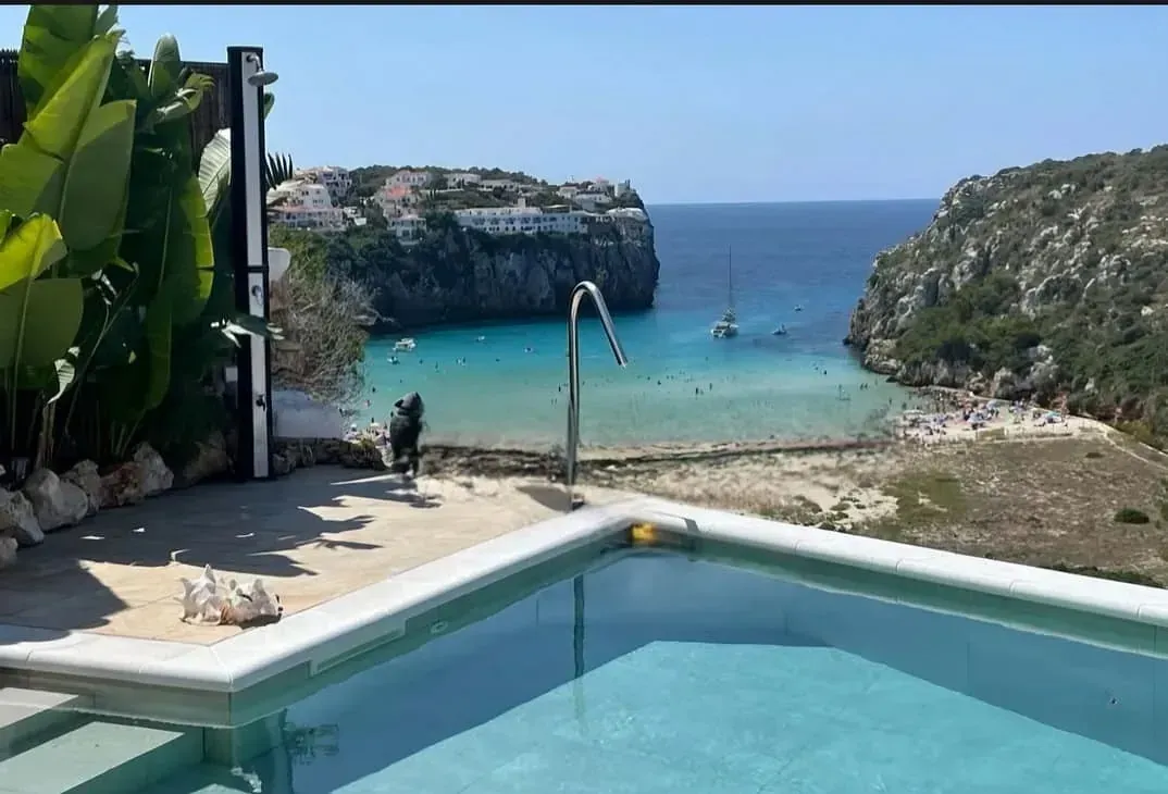 Hay una piscina con vista al mar.