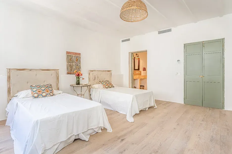 Un dormitorio con dos camas y una puerta verde.