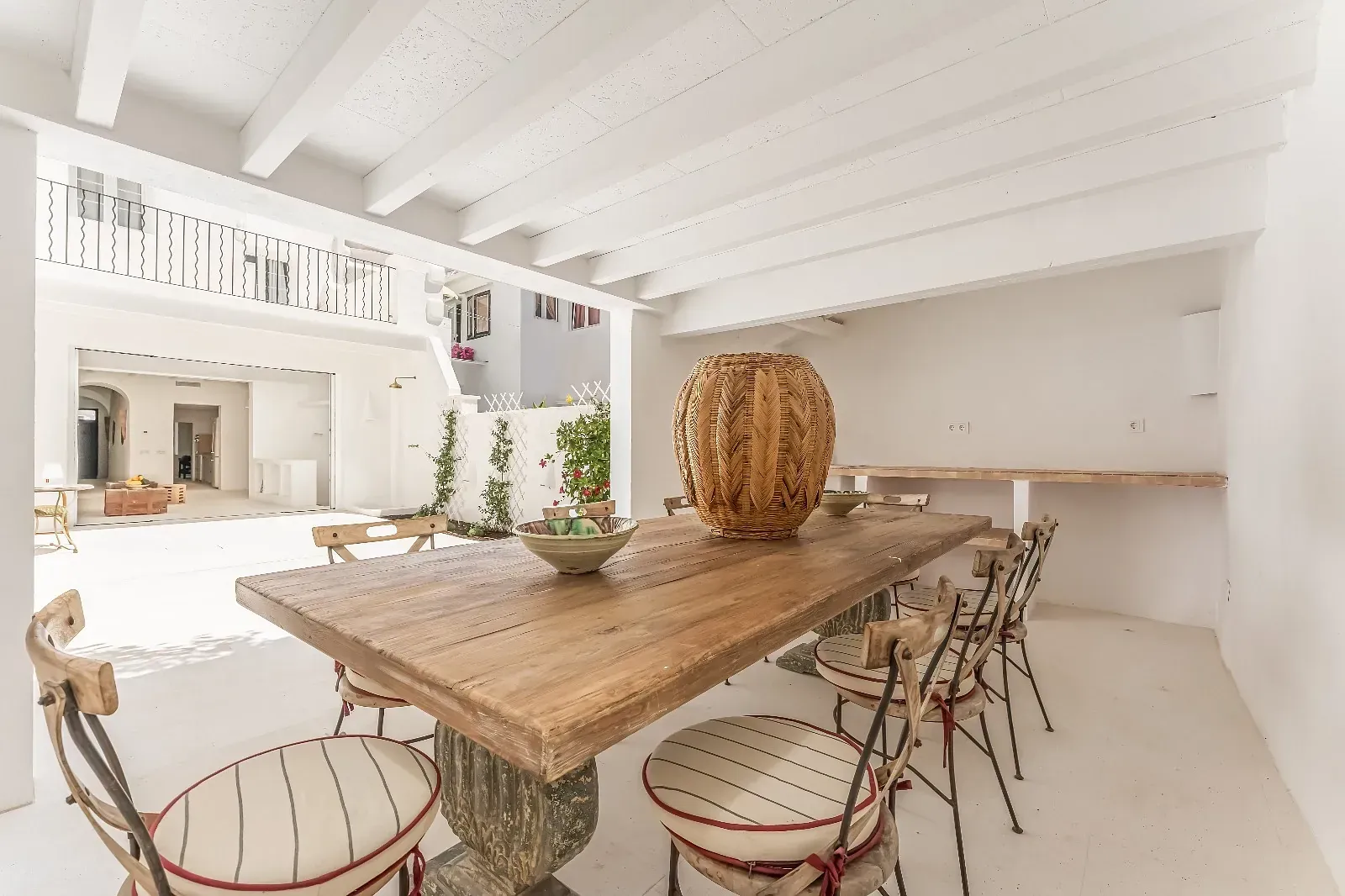 Un comedor con una larga mesa de madera y sillas.