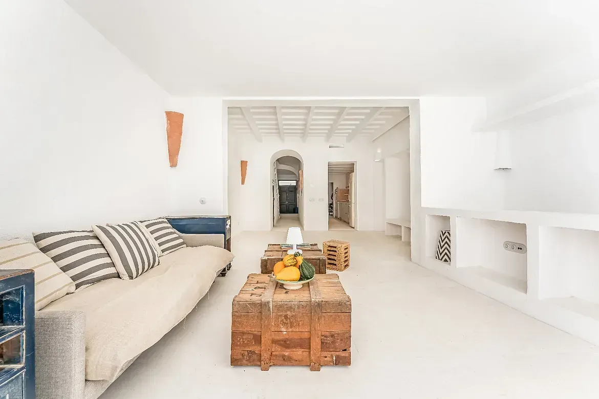 Una sala de estar con un sofá y una mesa de madera.
