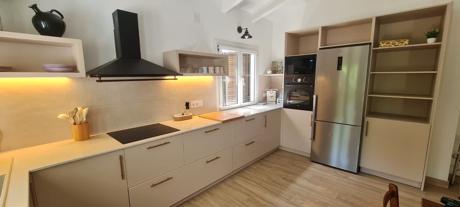Una cocina con gabinetes blancos y electrodomésticos de acero inoxidable.