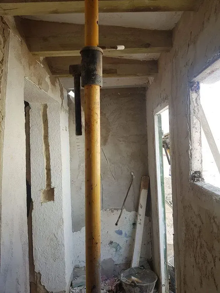 Un sitio de construcción con un poste amarillo en el medio de la habitación.
