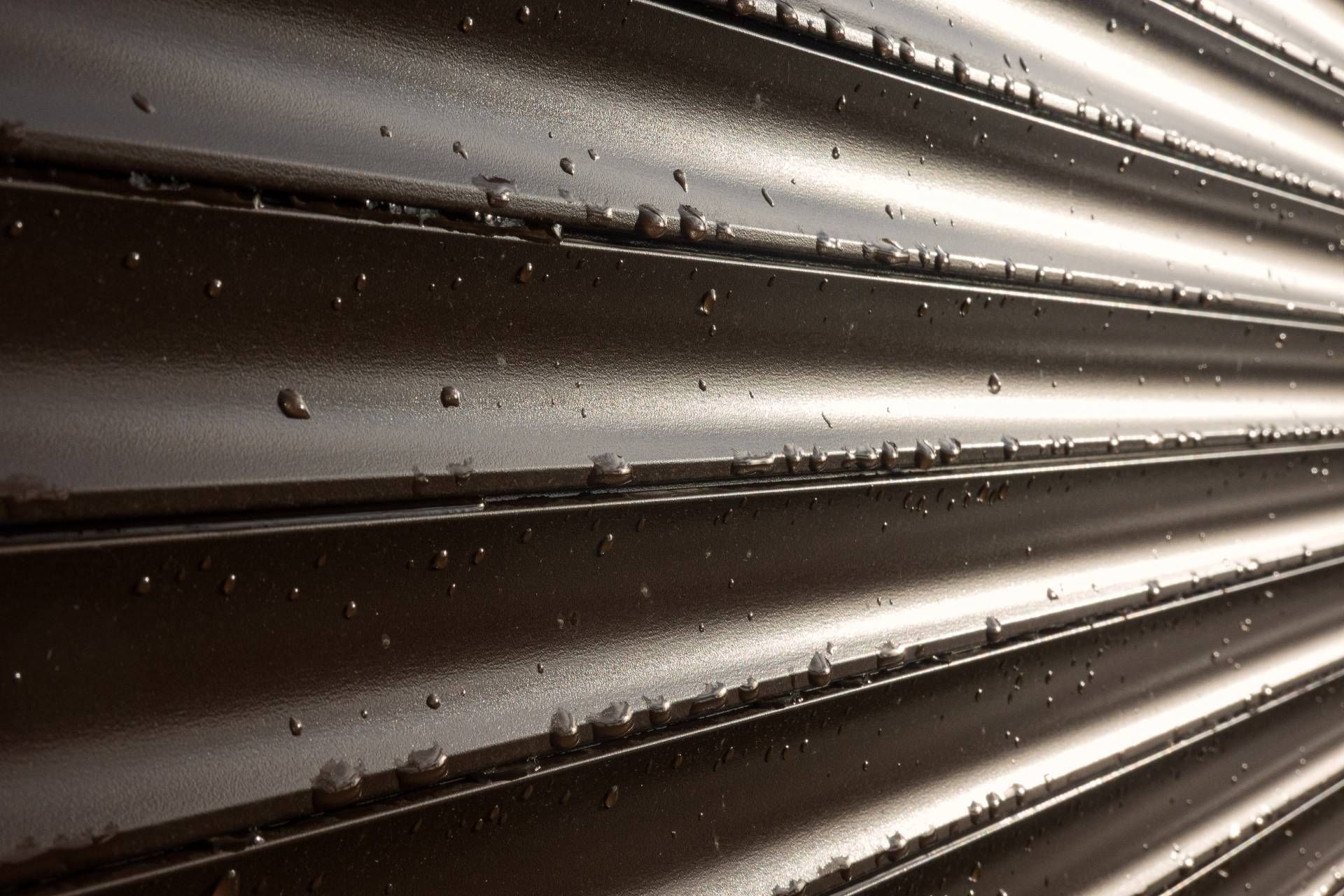 Eine Nahaufnahme einer Metallwand mit Wassertropfen darauf