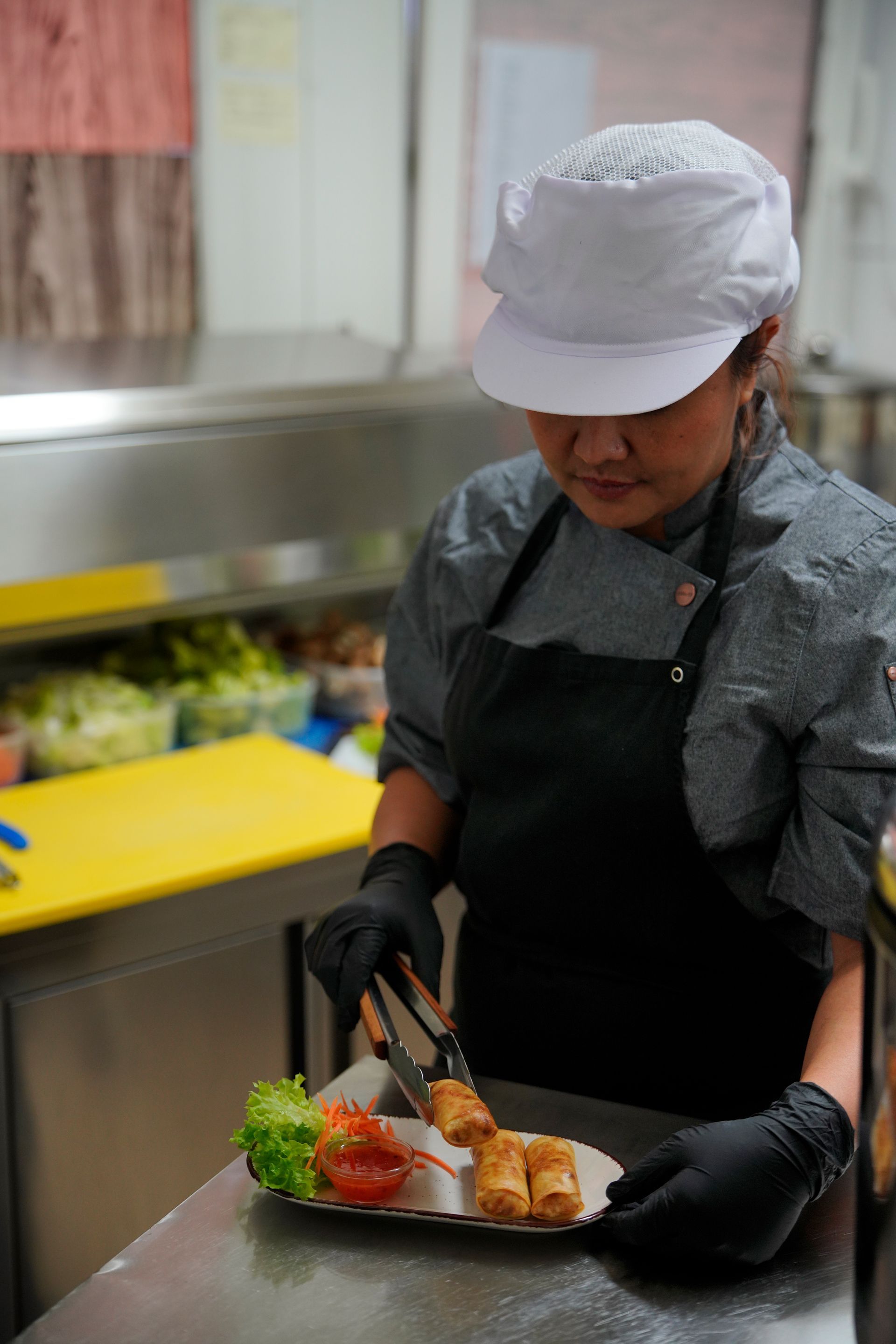 Eine Frau bereitet in einer Küche Essen zu.