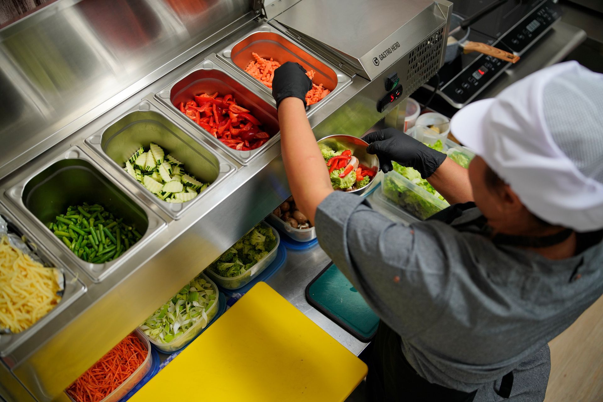 Eine Person bereitet in einer Küche Essen zu.