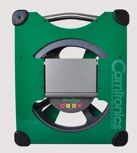 Dispositivo Camtronics verde y gris con módulo central y protectores de esquina negros.