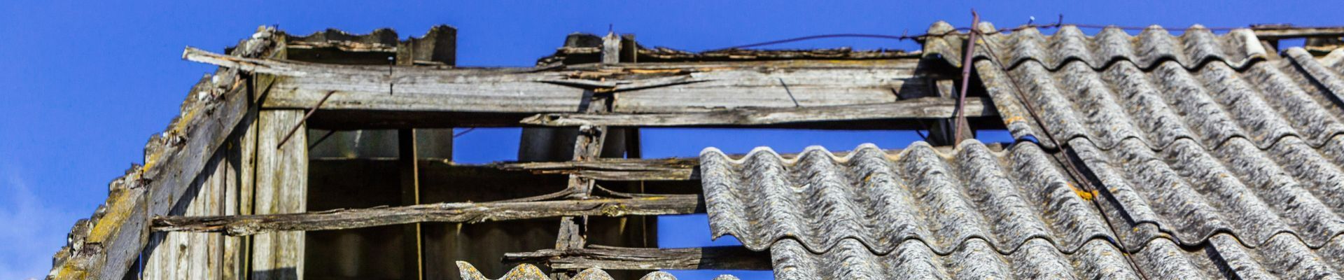 Détail d'une toiture dégradée en tuiles d'amiante 