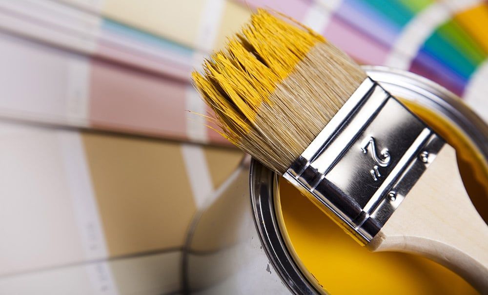 Pinceau sur un pot de peinture jaune