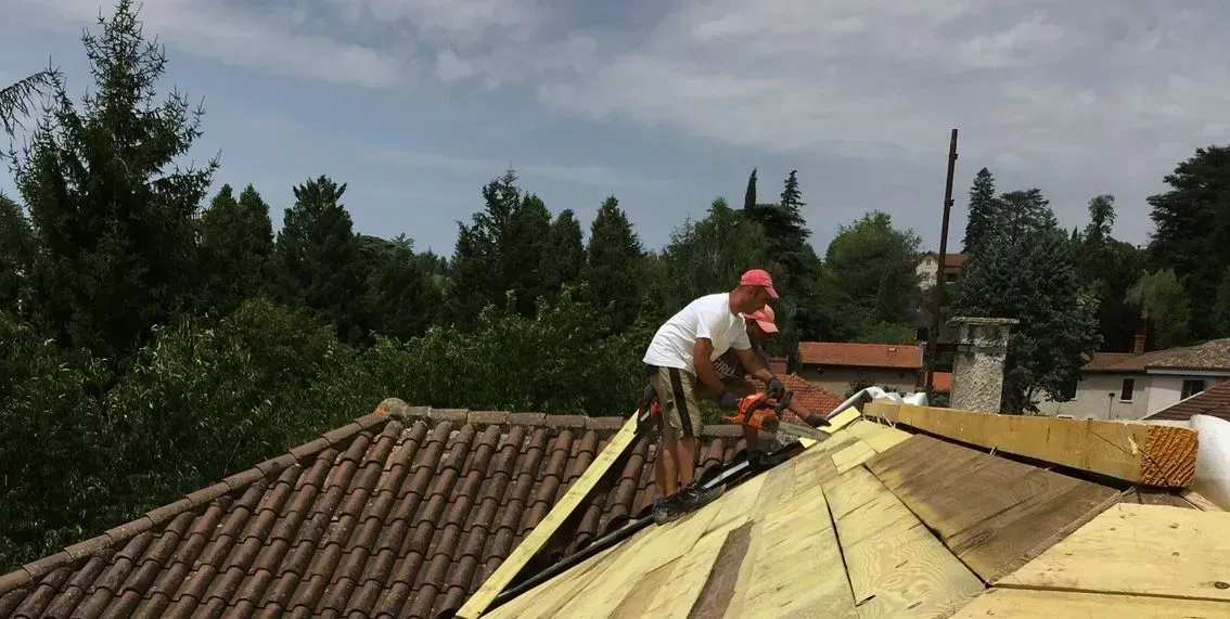 Artisan sur un toit avec un casquette rouge