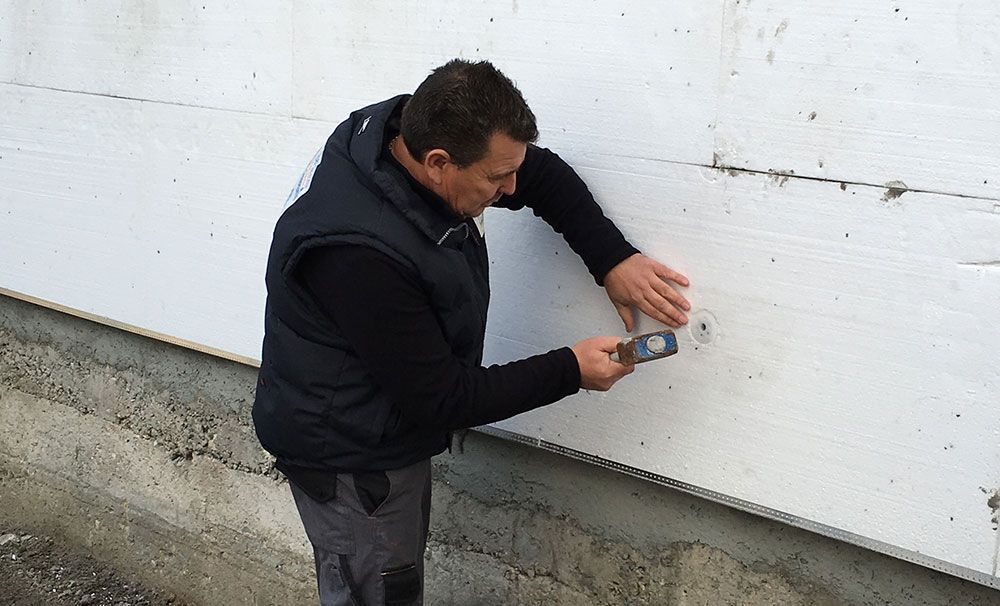 Artisan inspectant un mur blanc