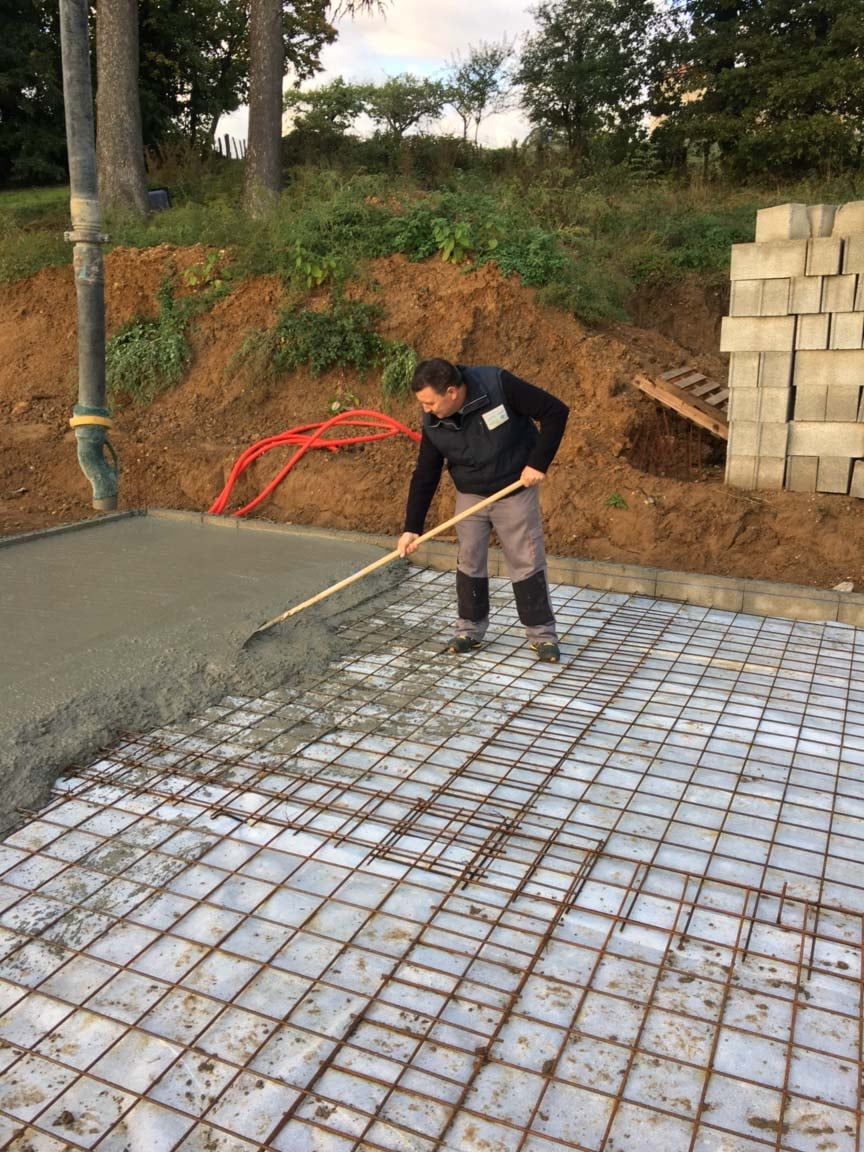 Professionnel étalant du béton sur une trame en fer