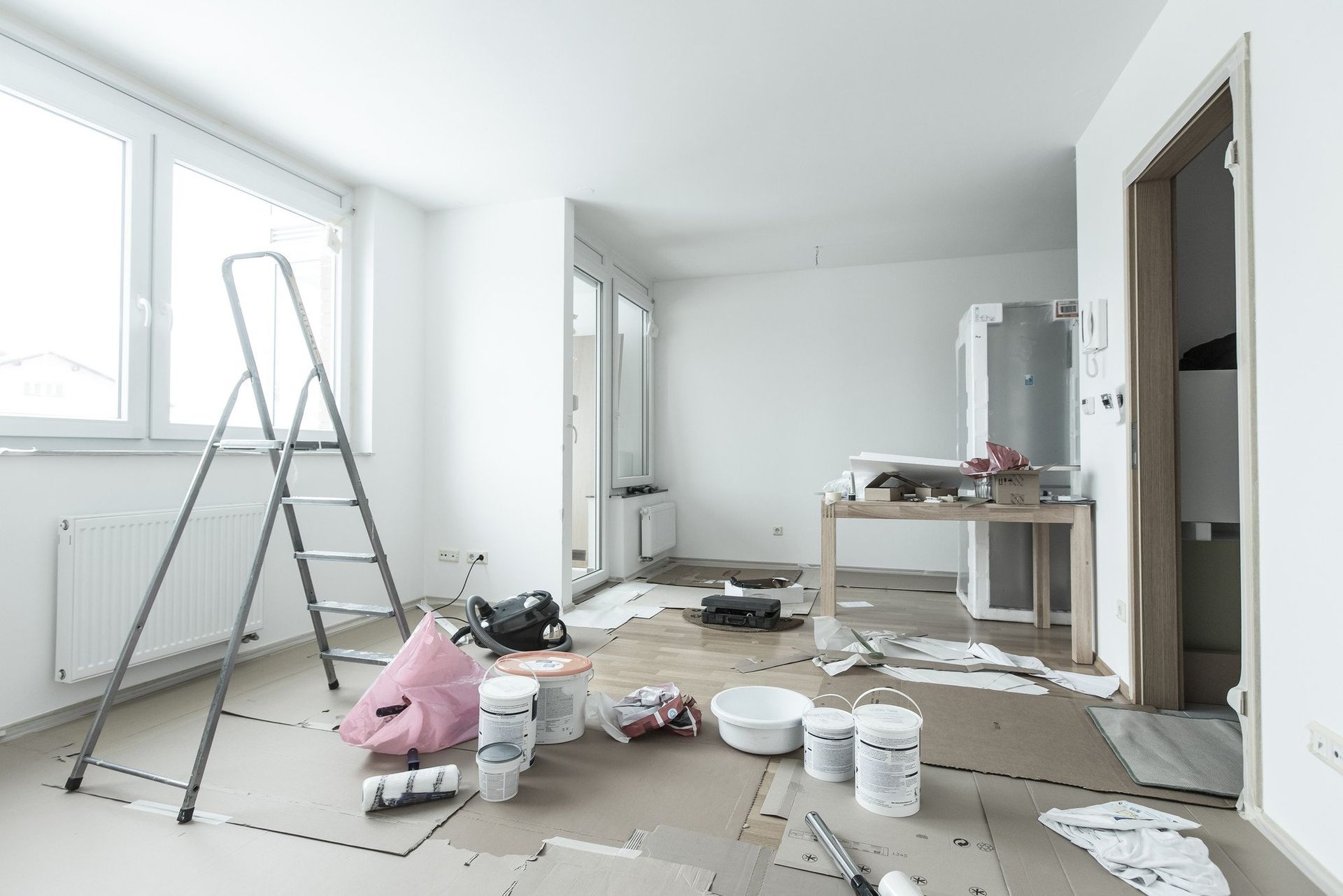Pièce en travaux avec échelle et pots de peinture