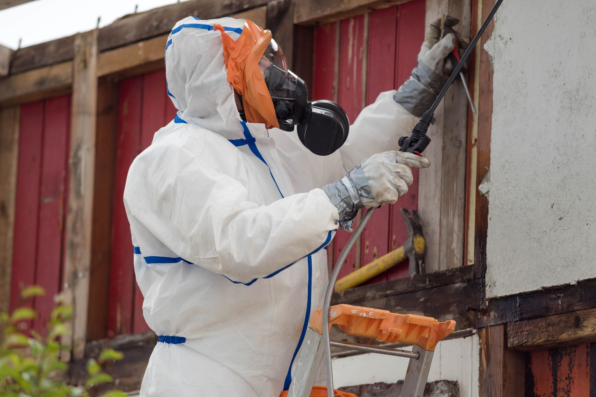 Homme en tenue et masque respiratoire devant un mur