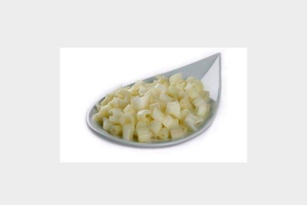 Una cuchara llena de patatas picadas sobre un fondo blanco.