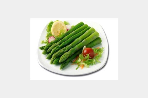 Espárragos en un plato blanco con lechuga y tomates