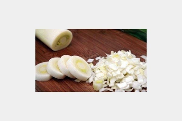 Cebollas en rodajas y cebollas picadas en una tabla de cortar de madera