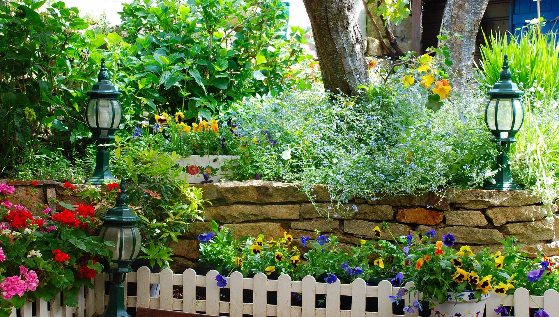 Des massifs de fleurs et un muret.