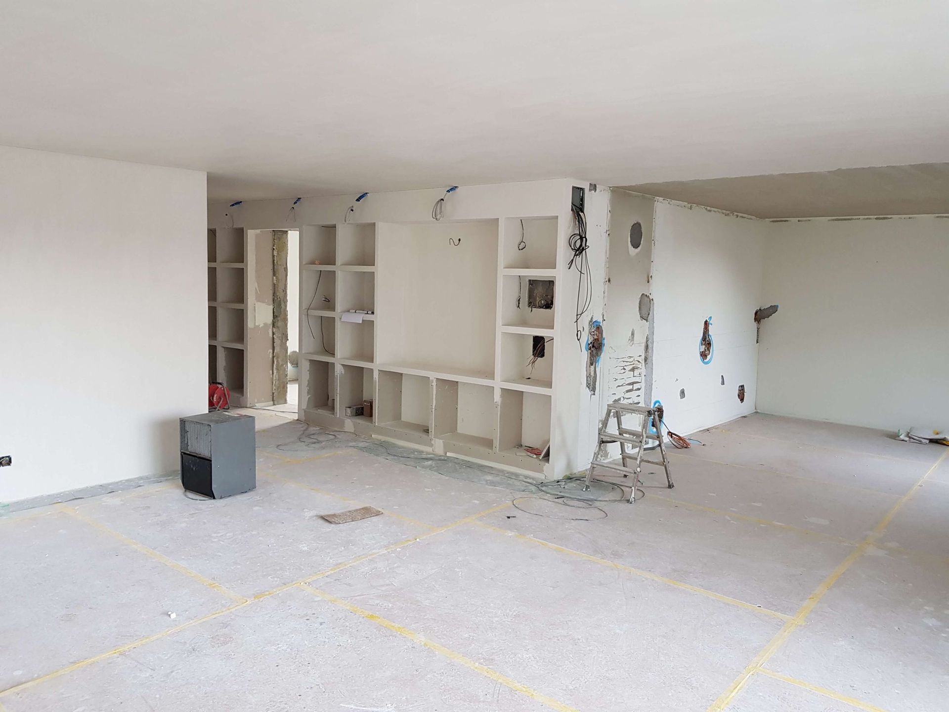 Ein leerer Raum mit vielen Fenstern und einem Holzboden. Mercuri Gipser & Maler AG