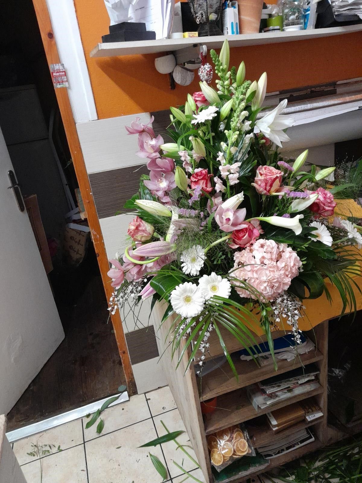 Devant de tombe avec beaucoup de plantes et de fleurs virant du blanc au rouge