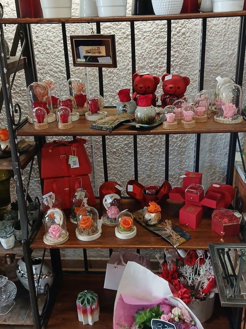 Des étagères remplies de cadeaux, de bocaux et de compositions florales rouges faits main sur le thème de la Saint-Valentin sont exposées.