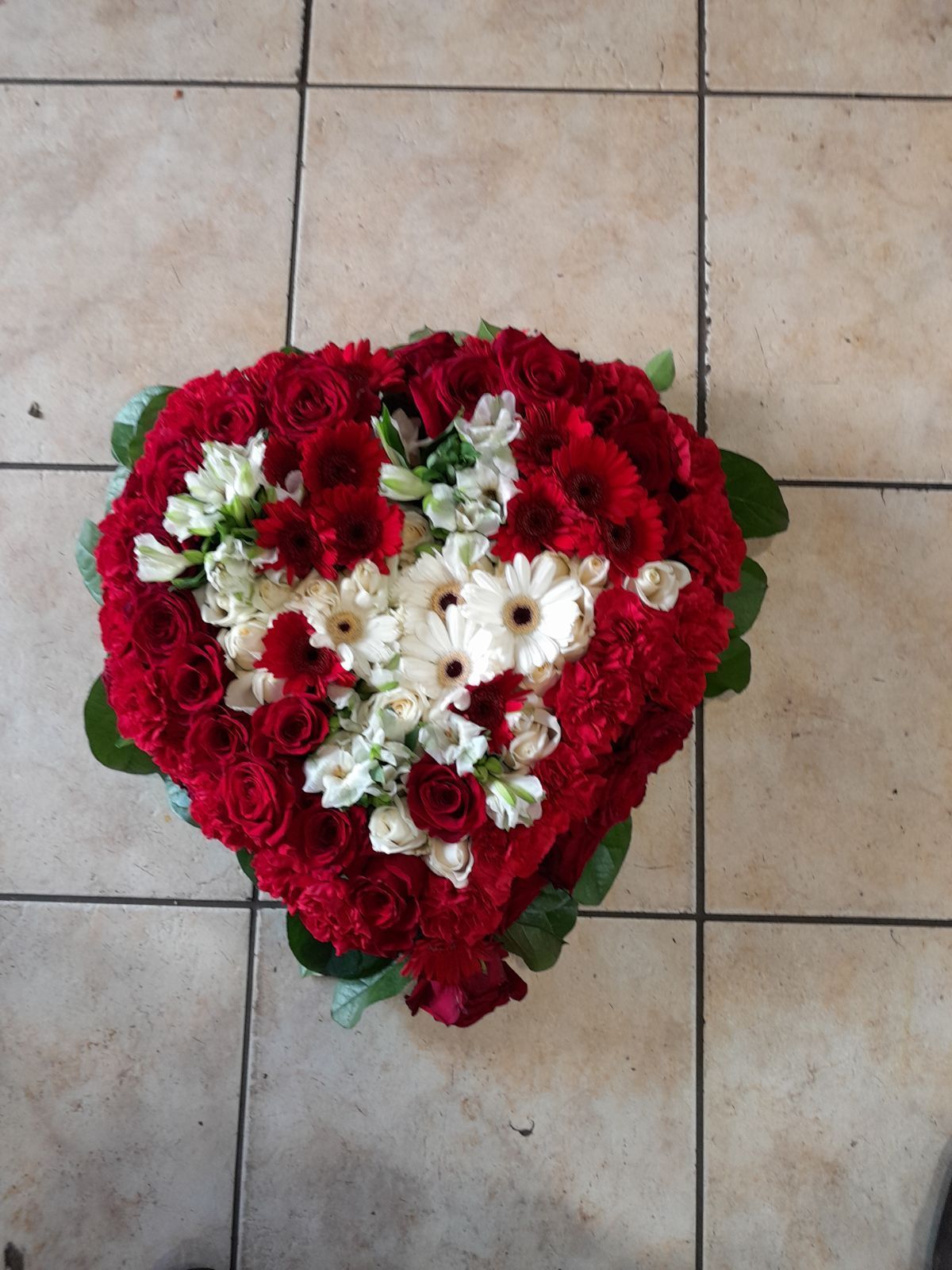 Composition en forme de cœur avec des fleurs rouges et blanches