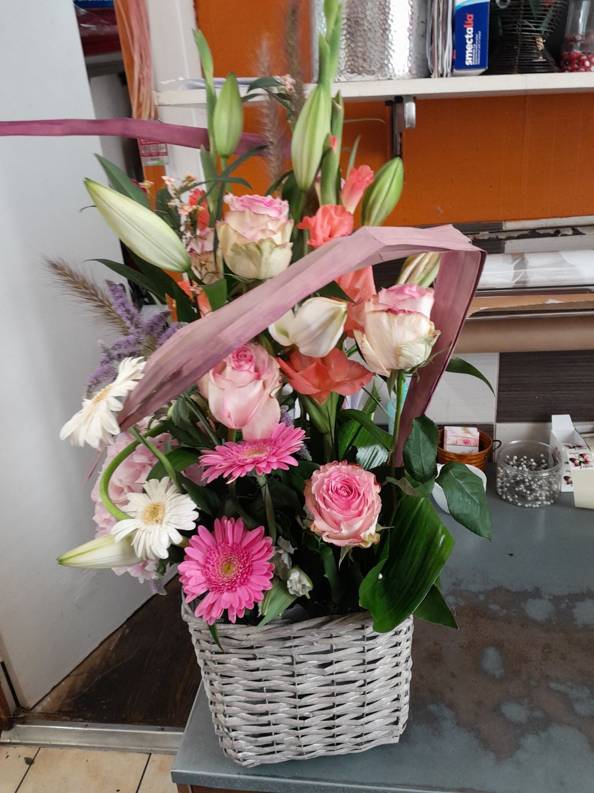 Composition florale avec des fleurs blanches et roses ainsi que quelques roses blanches