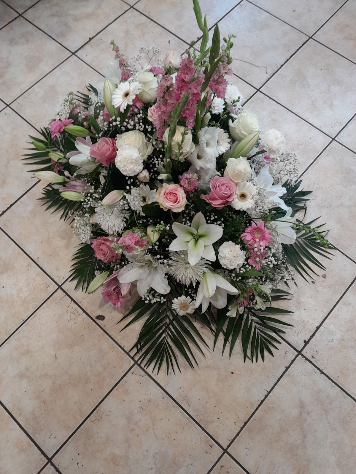 Gerbe en hauteur avec des fleur roses et blanches ainsi que d'autres fleurs blanches