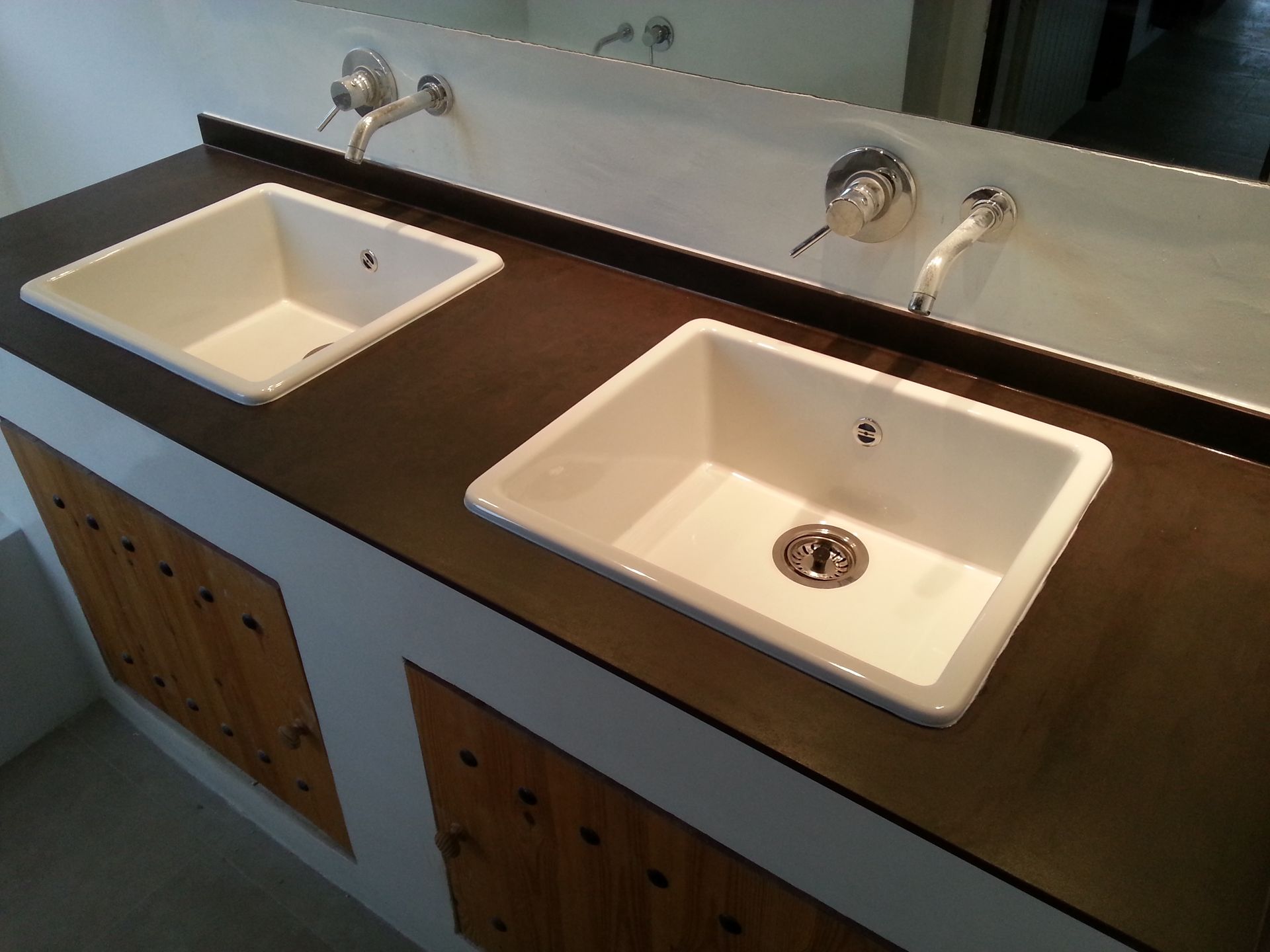 Un mostrador de baño con dos lavabos y un espejo.