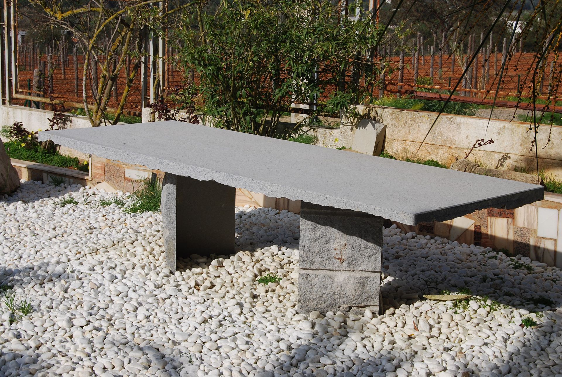 Un banco de piedra está sentado sobre una pila de grava.