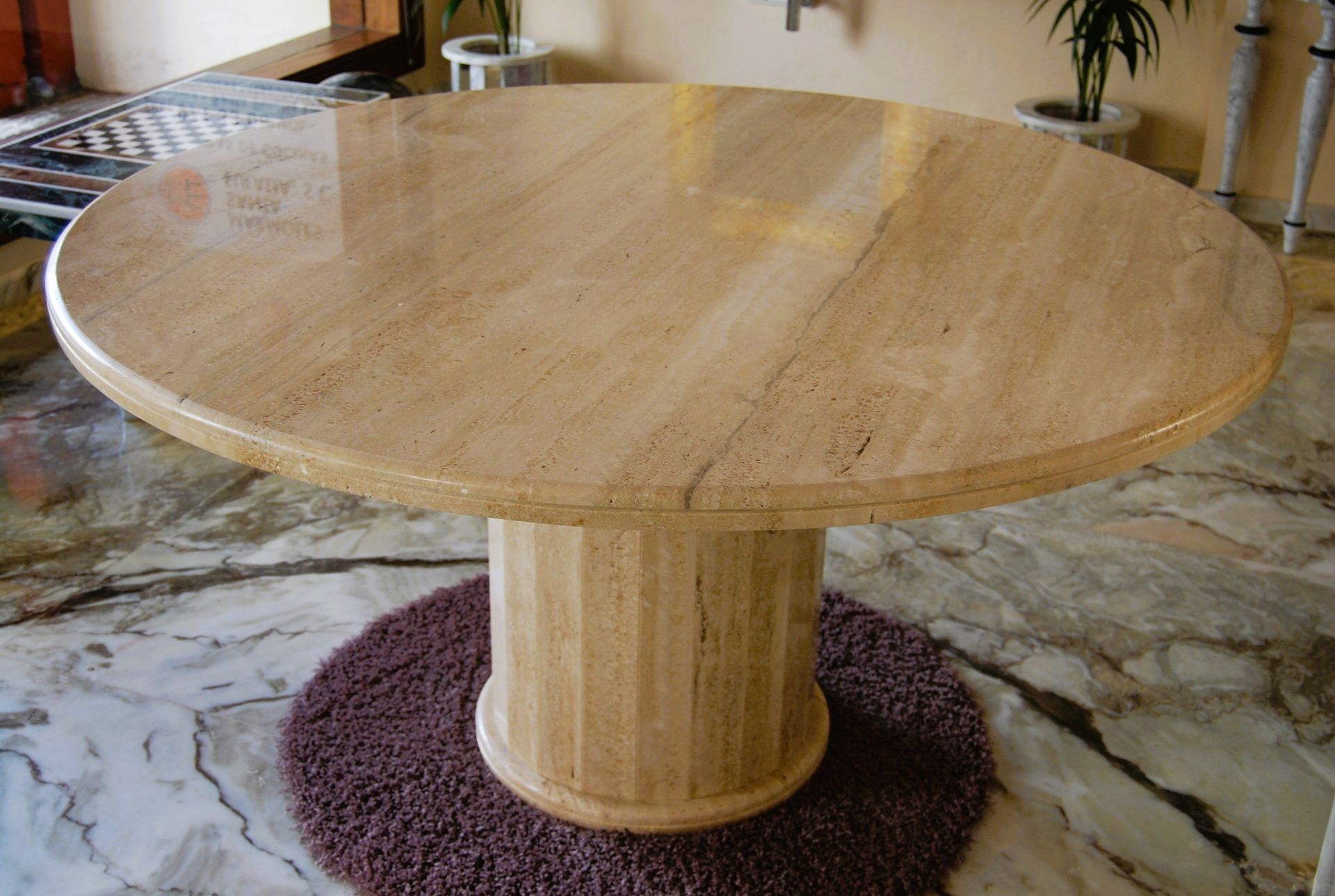 Una mesa redonda de mármol reposa sobre un suelo de mármol.