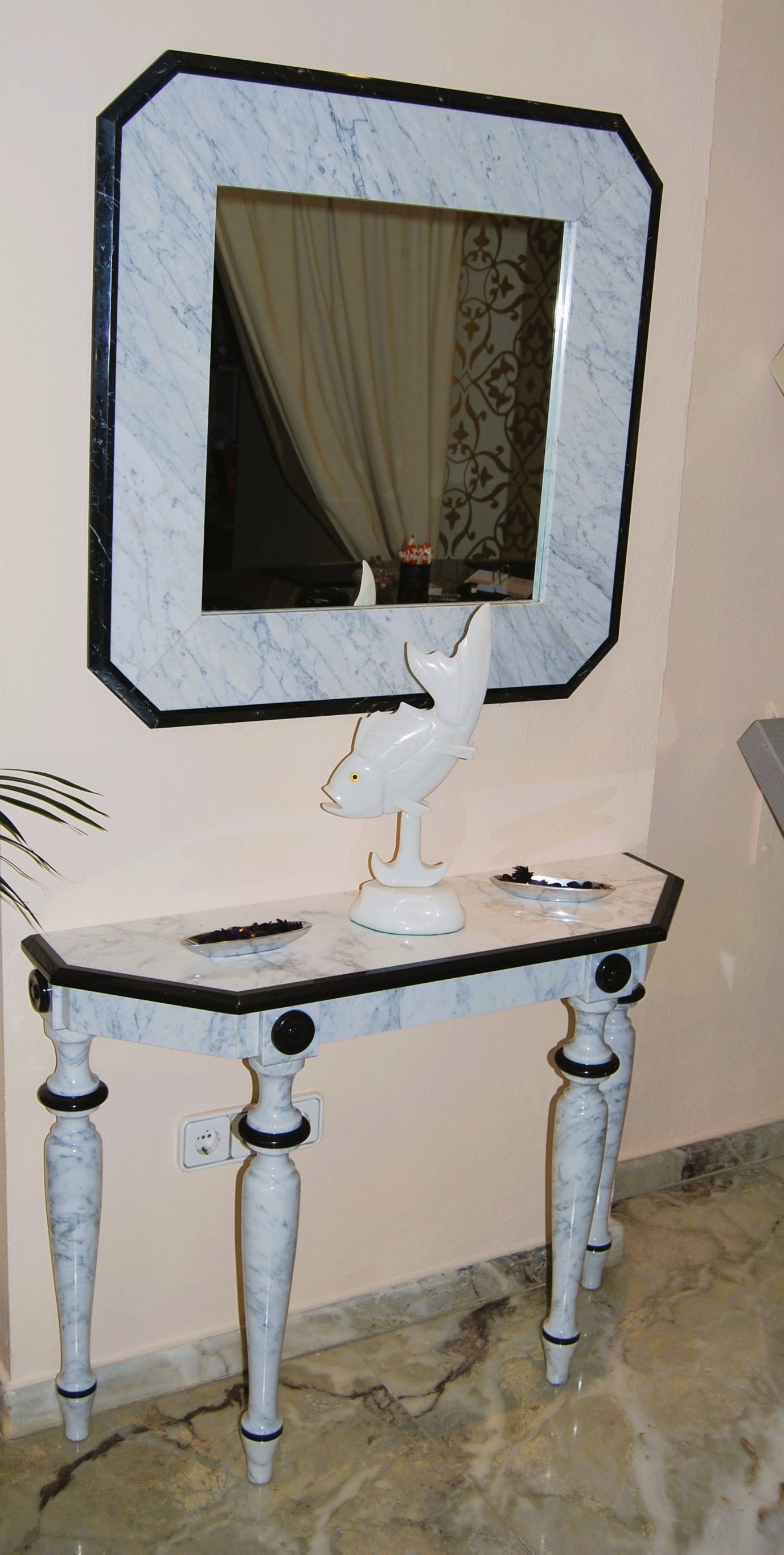 Una mesa blanca con un espejo encima.